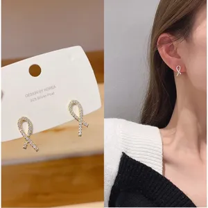 Detailed view of minimalist rhinestone ribbon bow stud earrings with 925 silver posts