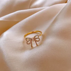 Detailed close-up of a gold-colored open ring with a sparkling bowknot design