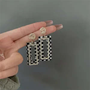 Detalle que muestra el patrón de cuadros y los diamantes de imitación en aretes