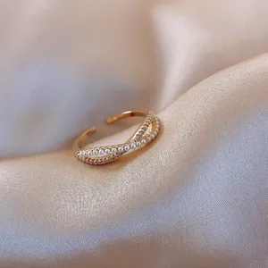 Detailed close-up of a minimalist gold-plated open ring with white pearls and zirconia
