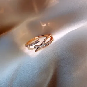 Detail view of rose gold criss-cross open ring with shimmering micro-paved zircons