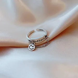 Close-up of S925 silver open ring with Good Luck engraving and smiley face charm
