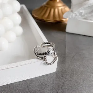 Detailed macro shot of a silver minimalist open ring with a smiley face and chain