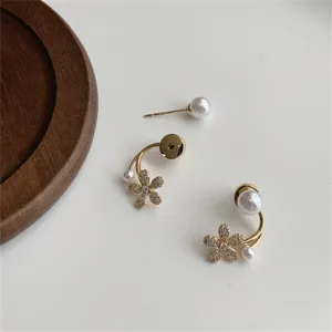 Detalle de elegantes pendientes de flores con perlas doradas y diseño versátil de dos usos