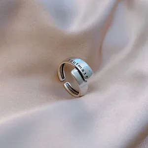 Close-up detail of a vintage silver open ring with 'soulmate' engraving on silk