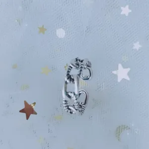 Close-up of a vintage silver-colored chain-link open ring for women on a starry mesh fabric.