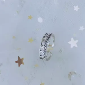 Close-up of minimalist open ring with chain texture and blue cubic zirconia