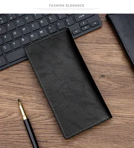 Men's black long PU leather wallet detail on wooden desk with office accessories