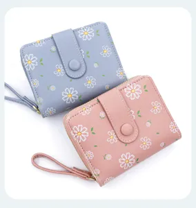 Vue détaillée des portefeuilles courts bleu et rose avec des motifs floraux de marguerites.