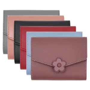 Detail view of small trifold women's wallets in various colors with a flower buckle