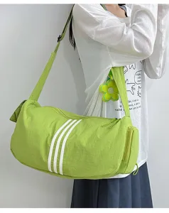 Modell trägt eine neongrüne Sporttasche mit drei weißen Streifen und Blumenanhänger