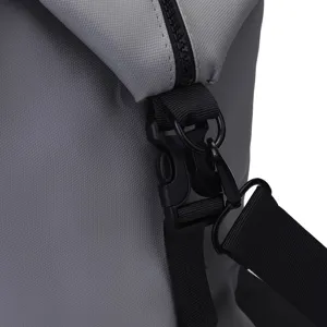 Gros plan sur la boucle en plastique durable et la sangle noire d'un sac de voyage gris sport