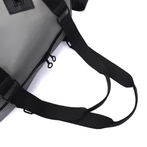 Gros plan sur les sangles noires et les doubles fermetures éclair d'un sac de voyage gris
