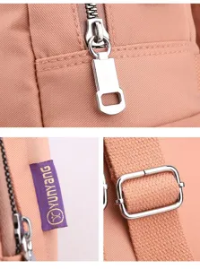 Detailed view of durable metal zipper and buckle on peach pink nylon mommy diaper bag