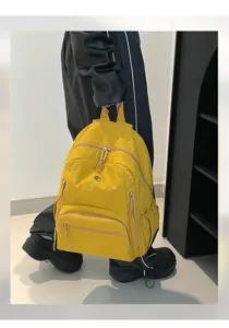 Vue détaillée d'un sac à dos scolaire en nylon imperméable jaune avec plusieurs poches