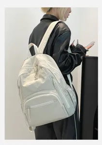 Grand sac à dos en nylon blanc imperméable pour l'école ou le voyage porté par un modèle