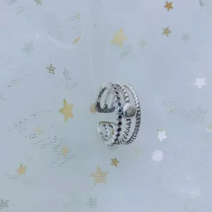 Detail view of a silver minimalist multi-layer open ring with dark stones on star mesh