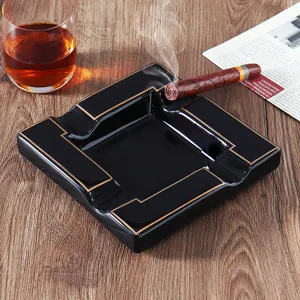 Close-up of black square melamine cigar ashtray with four slots and gold trim