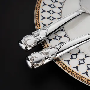 Detailansicht des silbernen Tortenhebergriffs mit Strasssteinen und Herzmotiv für Hochzeiten