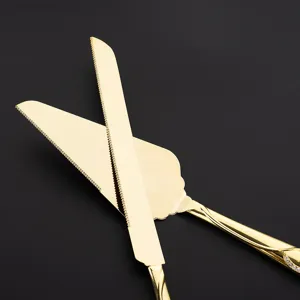 Detailansicht von goldenem Tortenmesser und Schaufel aus Edelstahl mit Wellenschliff
