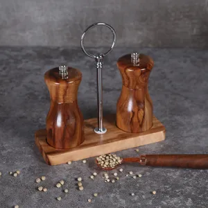 Dettaglio di due macinapepe manuali in legno su base di legno con manico in metallo