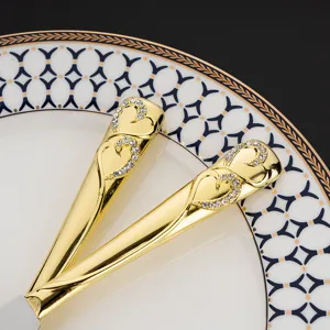 Makro-Detail von goldenen Hochzeitstorten-Spatelgriffen mit funkelndem Strass-Herzmuster