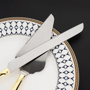Nahaufnahme von eleganten Tortenmesser und Tortenheber aus Edelstahl mit Goldgriff