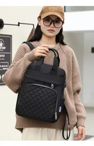 Stylish black quilted diaper backpack shown as a handheld mommy bag by an Asian model.