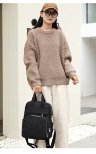 Stylish black quilted mummy backpack shown on an Asian model in a minimalist setting