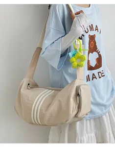 Beige Sporttasche mit drei weißen Streifen, getragen von einem Modell für Fitness
