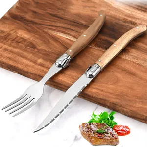 Close-up detail of serrated steak knife and fork set featuring elegant acacia wood handles