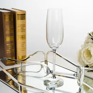 Close-up of elegant champagne glasses with crystal-encrusted stems on a mirror tray