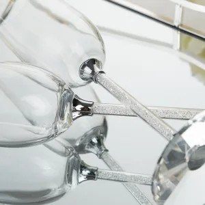 Macro detail of elegant champagne glasses featuring stems filled with sparkling crystals.