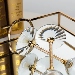Detail view of crystal champagne glasses with gold foil stems on a gold mirrored tray