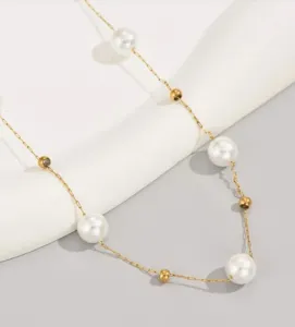 Detailweergave van een verfijnde gouden ketting met elegante witte imitatieparels.