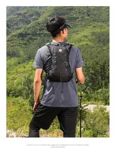 Man wearing a black running vest hydration pack in an outdoor mountain hiking setting