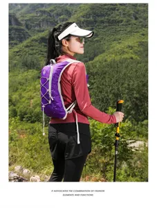 Purple outdoor hydration vest backpack shown on a model during a scenic mountain hike.