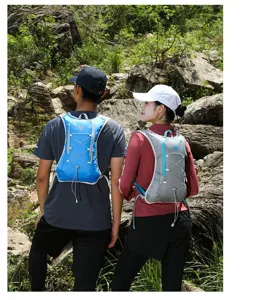 Two hikers wearing blue and grey lightweight outdoor hydration running vest backpacks