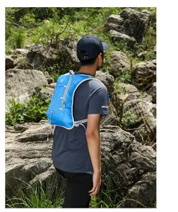 Lightweight blue running hydration vest shown on model in outdoor rocky terrain