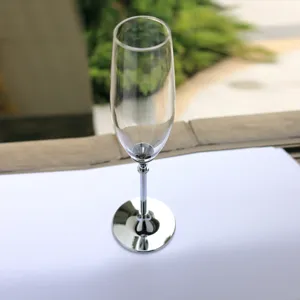 Nahaufnahme eines eleganten Champagnerglases mit poliertem silbernem Metallschaft