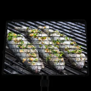 Detail showing seasoned fish being grilled in a non-stick rectangular BBQ basket.
