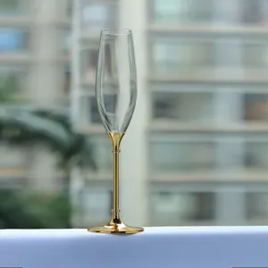 Detailansicht eines eleganten Champagnerglases mit goldenem Metallstiel und Kristall