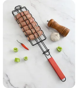 Professional detail view of a black iron sausage grill basket with a red handle