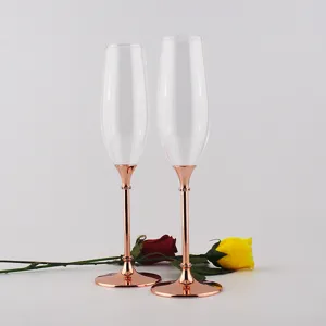 Elegante Champagnerflöten mit roségoldenen Metallstielen auf weißem Hintergrund