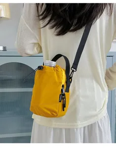 Detail view of yellow lightweight outdoor crossbody bucket bag with drawstring closure.