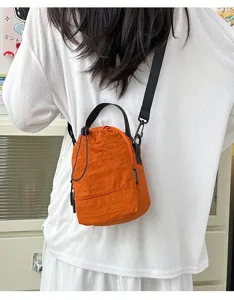 Stylish orange nylon lightweight crossbody bucket bag shown being worn by a model