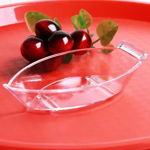 Close-up of transparent PC boat-shaped salad bowl with snacks and berries background
