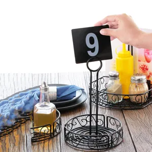 Close-up of a hand placing a table number card into a black iron condiment holder