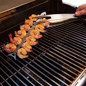 Close-up of shrimps on a fishbone-shaped stainless steel barbecue skewer on a hot grill