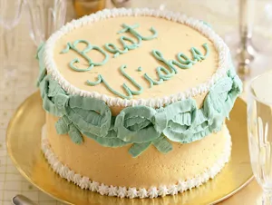 Close-up of a cream cake with Best Wishes lettering, showing baking results